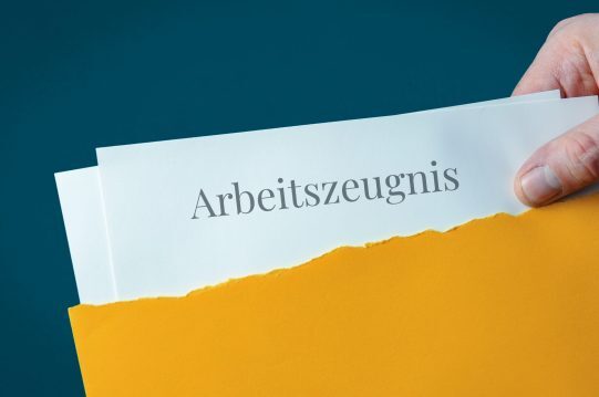 Arbeitszeugnis. Briefumschlag wird geöffnet. Hand entnimmt Unterlagen. Text auf Post-Brief. Arbeitszeugnis